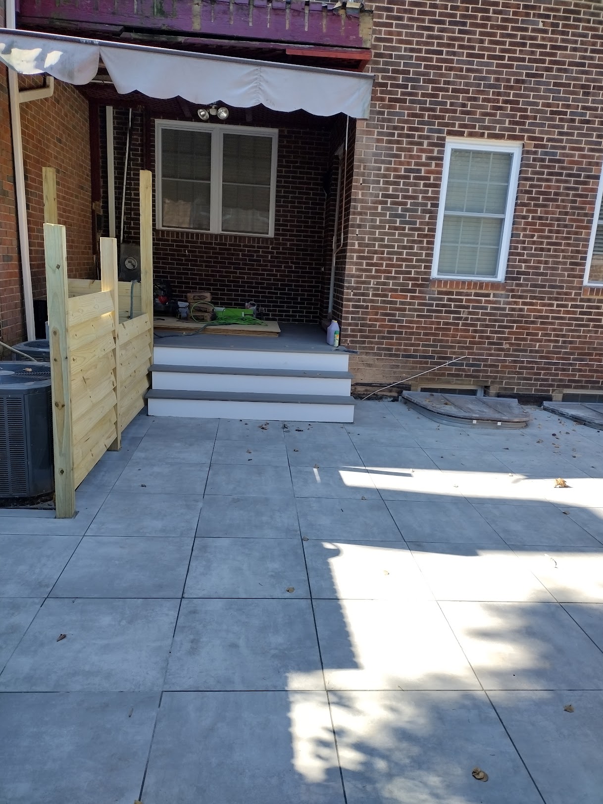 Finished scored concrete patio with new deck steps and privacy wall