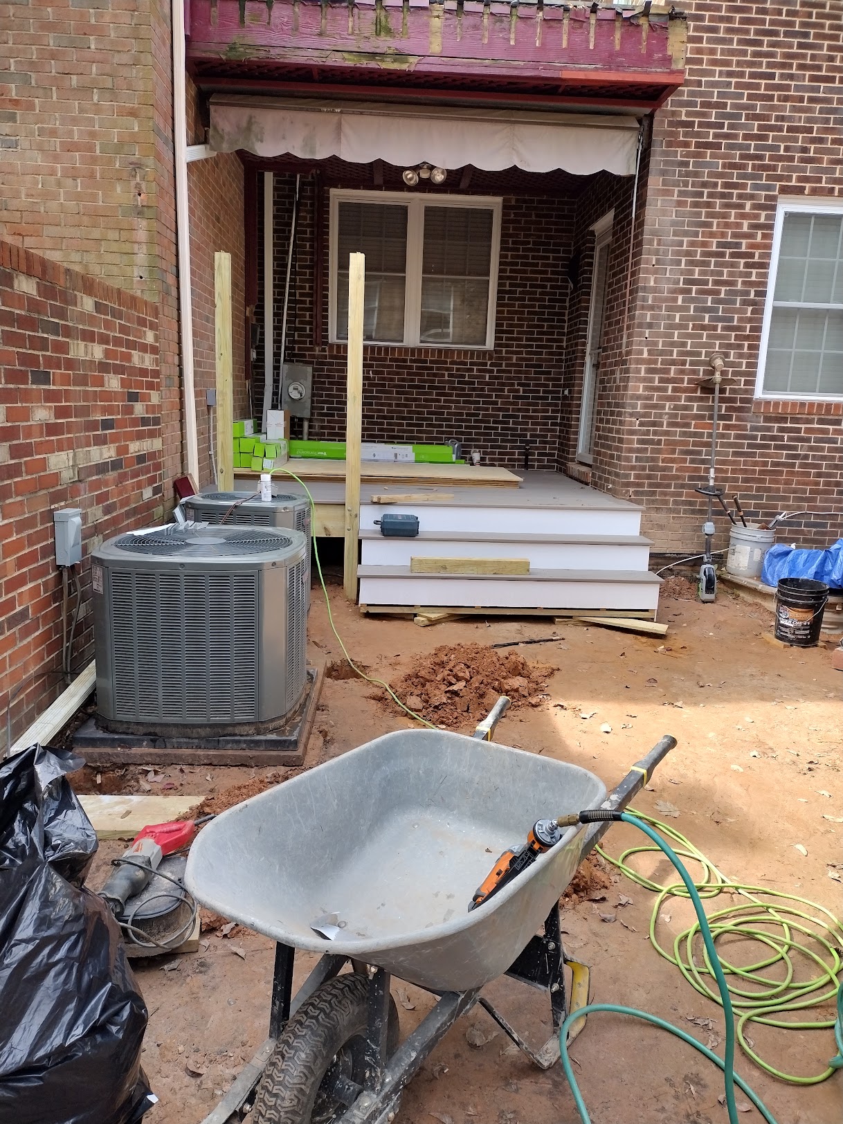 Dirt backyard with construction debris before concrete patio install