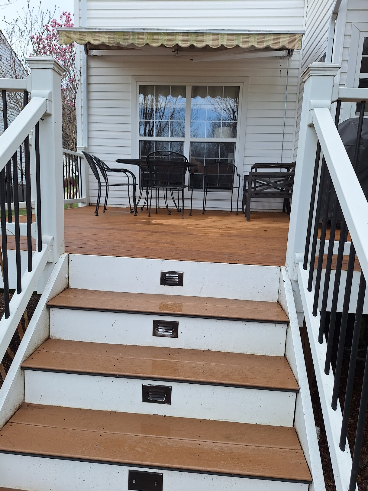 Refinished wood deck with steps and patio furniture