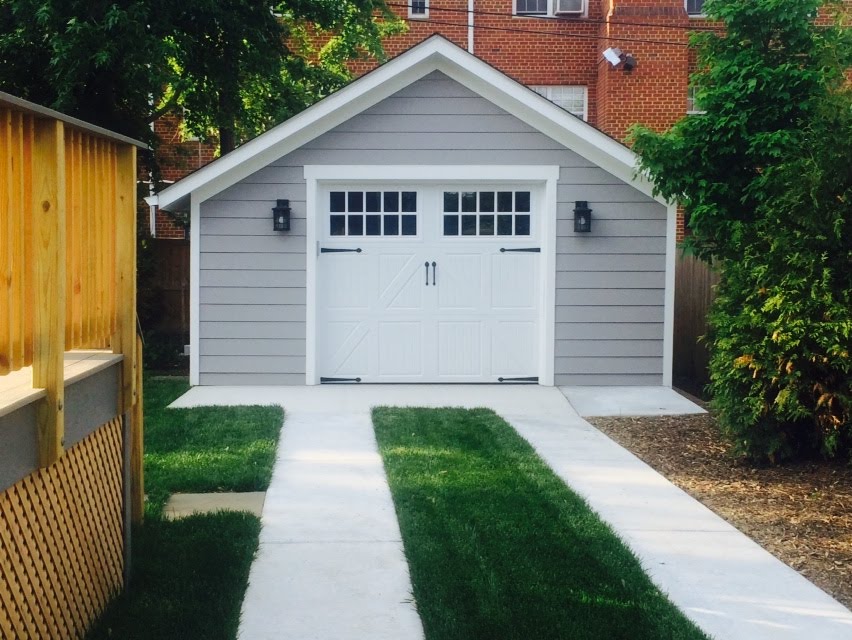 Custom built detached garage with carriage doors and gray siding