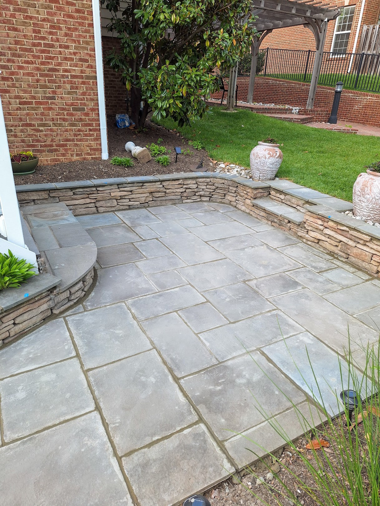 Finished bluestone patio with stacked stone wall