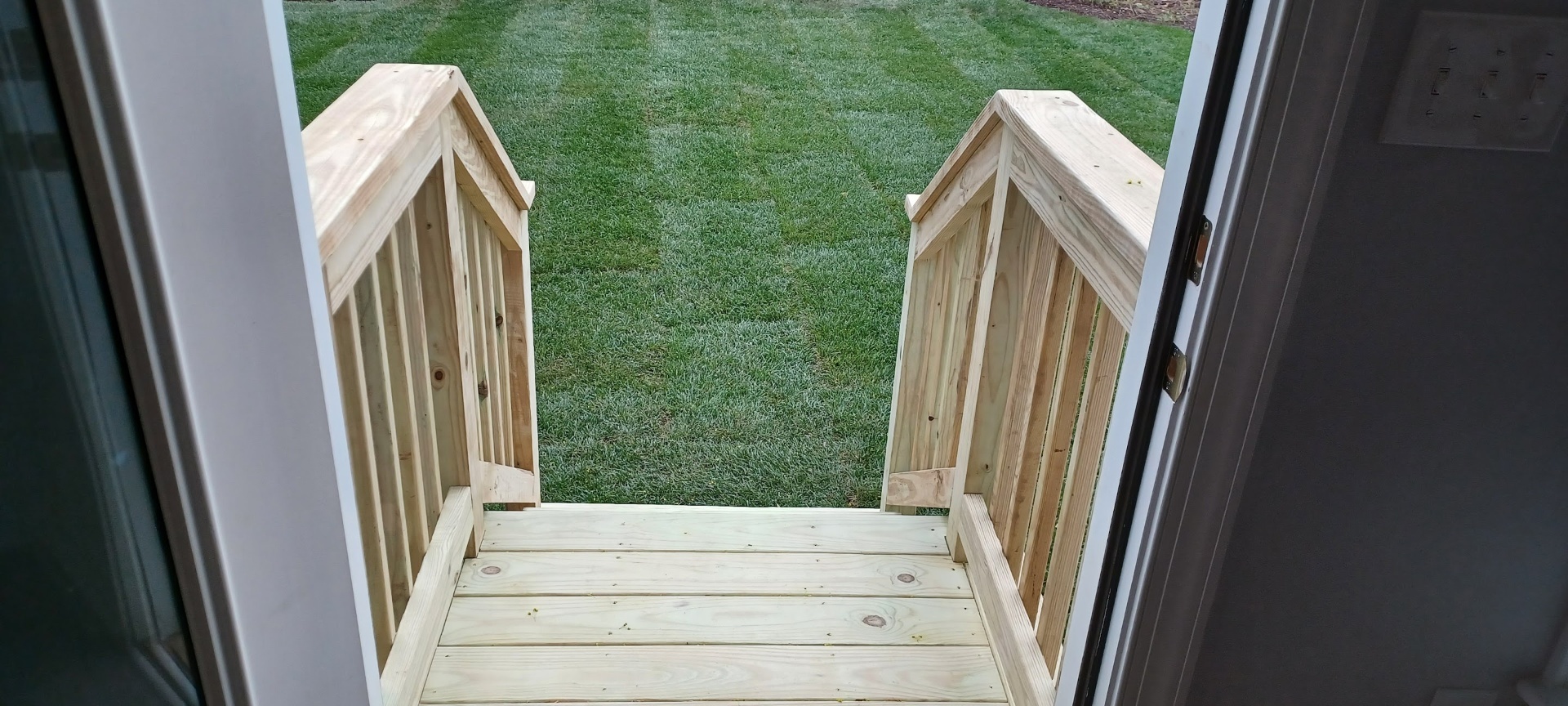 Custom built wooden exterior stairs and landing with railings